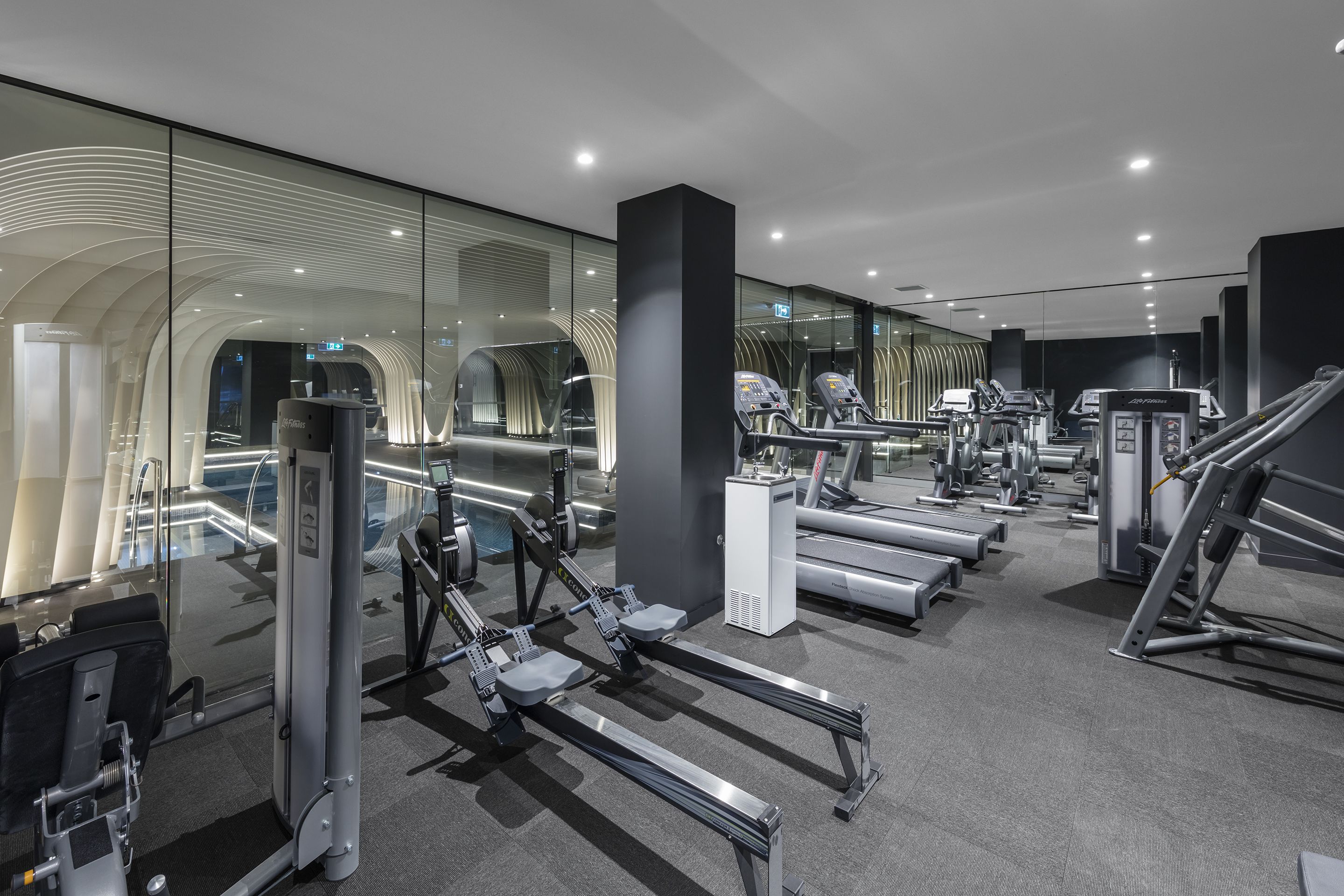 Ett modernt gym med olika typer av träningsutrustning, inklusive löpband och styrketräningsmaskiner.