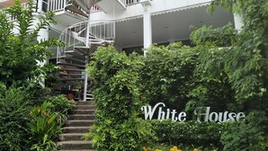 A white house with a spiral staircase leading to a balcony. - White House Mountian Beach Resort (Klaeng)