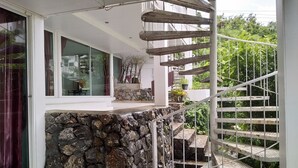 A spiral staircase with a stone base and metal railings, leading to a balcony with a glass door and curtains. - White House Mountian Beach Resort (Klaeng)