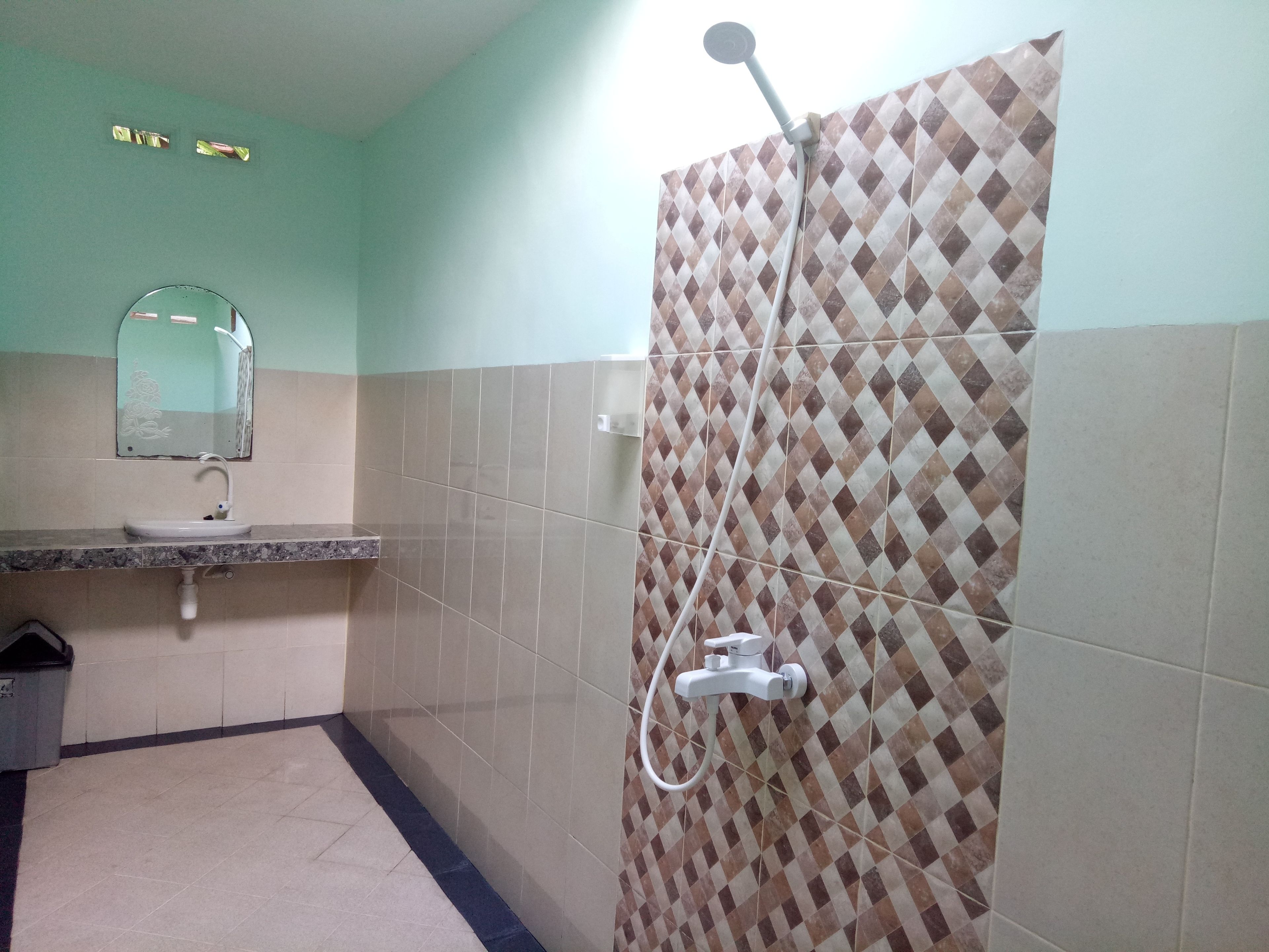 Un baño con lavamanos, espejo y ducha.