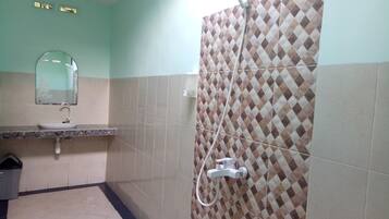 Un baño con lavamanos, espejo y ducha.