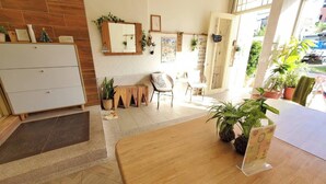 A cozy hotel lobby with a wooden reception desk, a seating area with chairs, and a large mirror on the wall. - Suiian inn  (Hengchun)