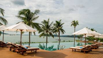 Una piscina al aire libre, tumbonas
