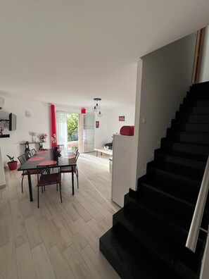 Enjoy meals in the dining area with a table and chairs, and access to a kitchen with a refrigerator and bench.