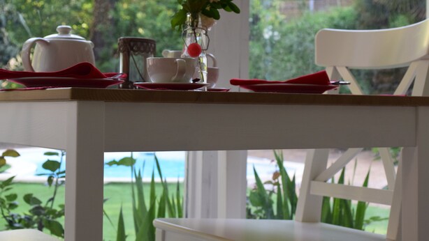 A dining table set with white teacups, a white teapot, and a vase with white flowers. - Maison des Ingénieurs (Molieres-sur-Ceze)