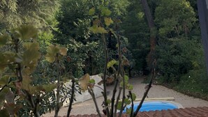 A pool area with a view of surrounding trees and a building. - Maison des Ingénieurs (Molieres-sur-Ceze)