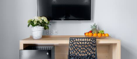 A modern kitchen with a built-in refrigerator, a wooden countertop, and a wall-mounted TV.