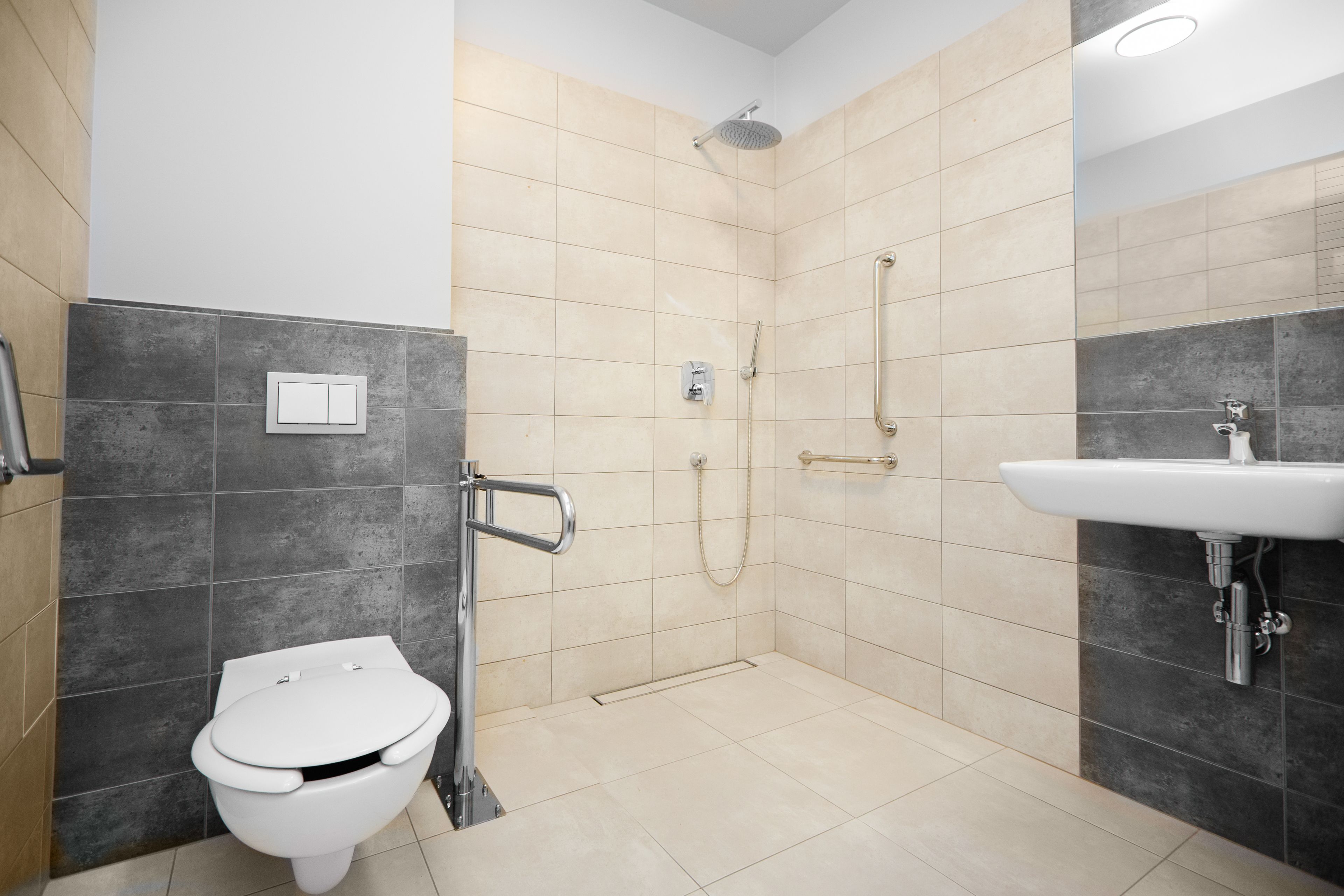 A modern bathroom with a toilet, shower, and sink.