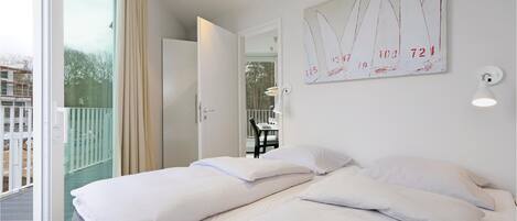 Een hotelkamer met twee bedden, een balkon, uitzicht en een schilderij aan de muur.