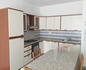 Apartamento, 2 quartos | Cozinha privada | Geladeira grande, cooktop, talheres/pratos/utensílios de cozinha