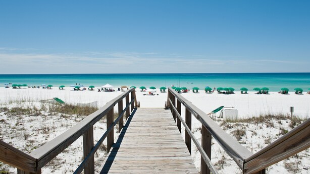 A wooden boardwalk leading to a beach with green umbrellas. - Beautiful Views, 4 Bedroom Gulf Front with 2 Master Suites, Sleeps 12 (Miramar Beach)