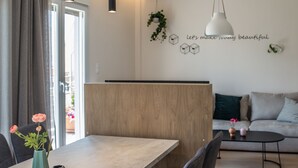 Ein moderner Essbereich mit einem langen Holztisch, schwarzen Stühlen und Pendelleuchten.