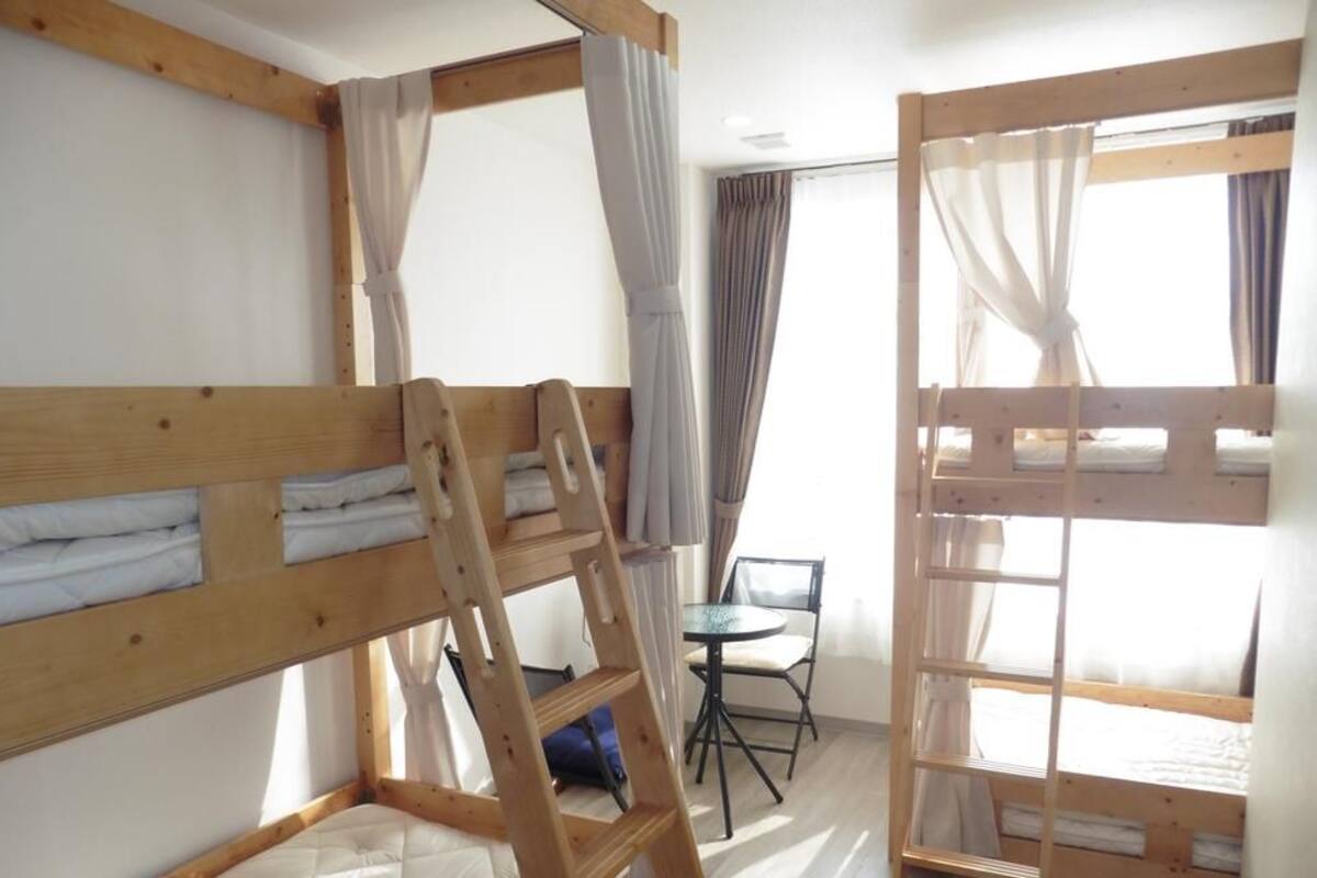 Une chambre avec deux lits superposés, une petite table et une chaise.