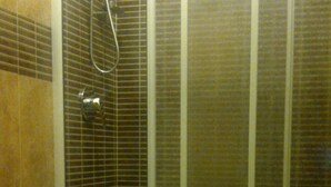 Un baño con inodoro, cabina de ducha y paredes con azulejos.