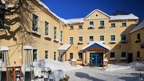 Un hotel amb façana groga, finestres cobertes de neu i un rètol que diu "Buntes Haus Seifen".