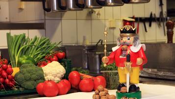 A kitchen counter with fresh vegetables and a nutcracker figurine.