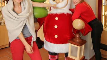 Een persoon die met een Sinterklaasbeeld interageert in een ruimte met betegelde vloer en planken op de achtergrond.