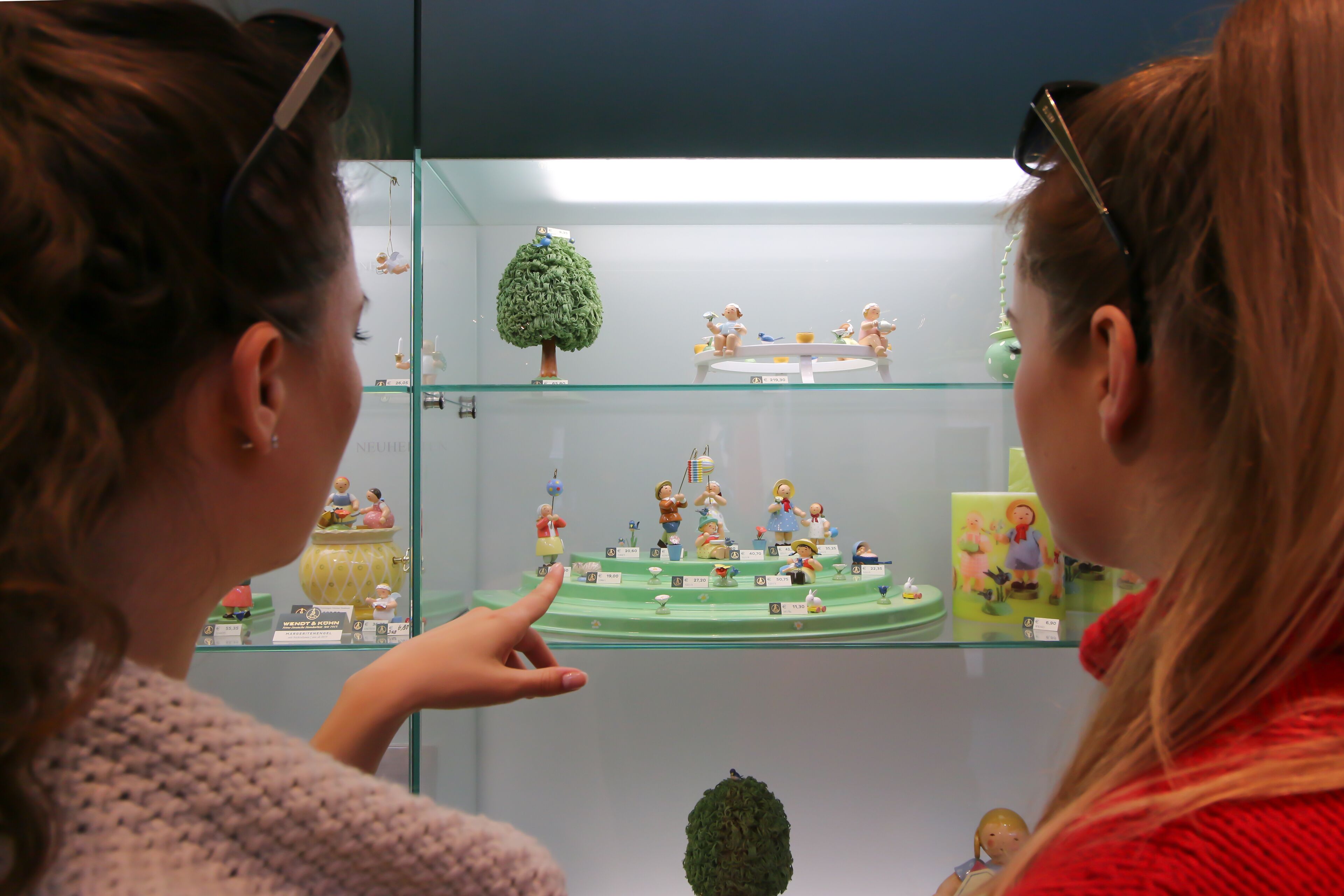 Eine Vitrine mit Figuren und einem kleinen Baum.