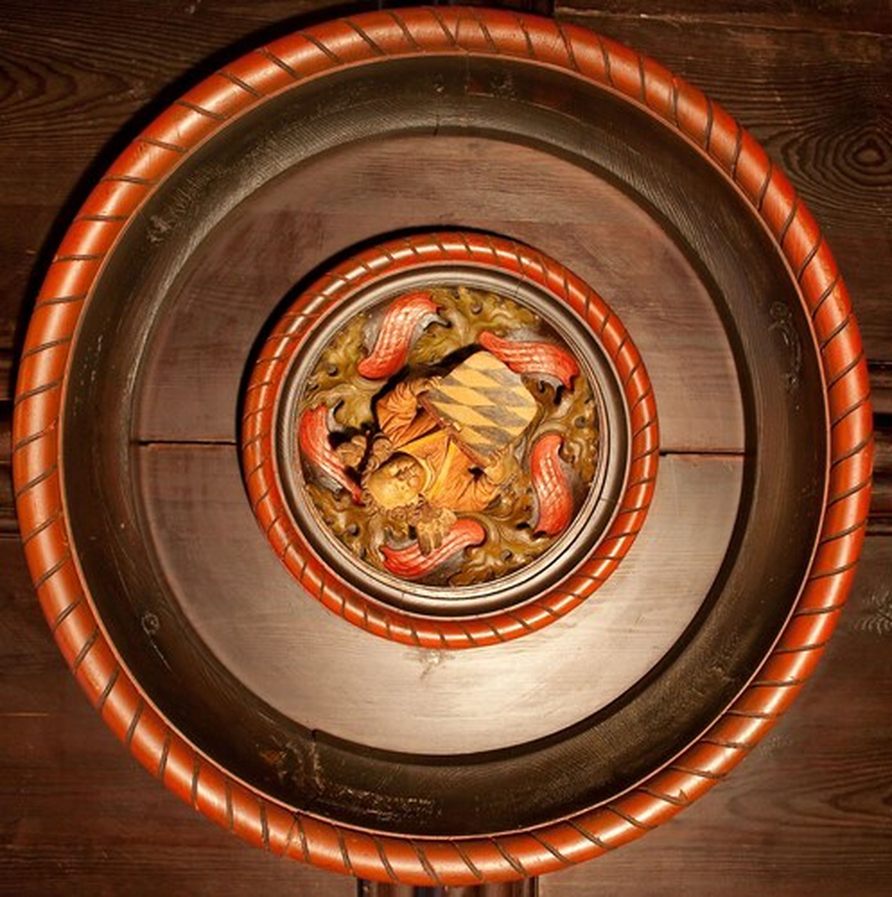Una mesa de madera redonda con un diseño decorativo en el centro.