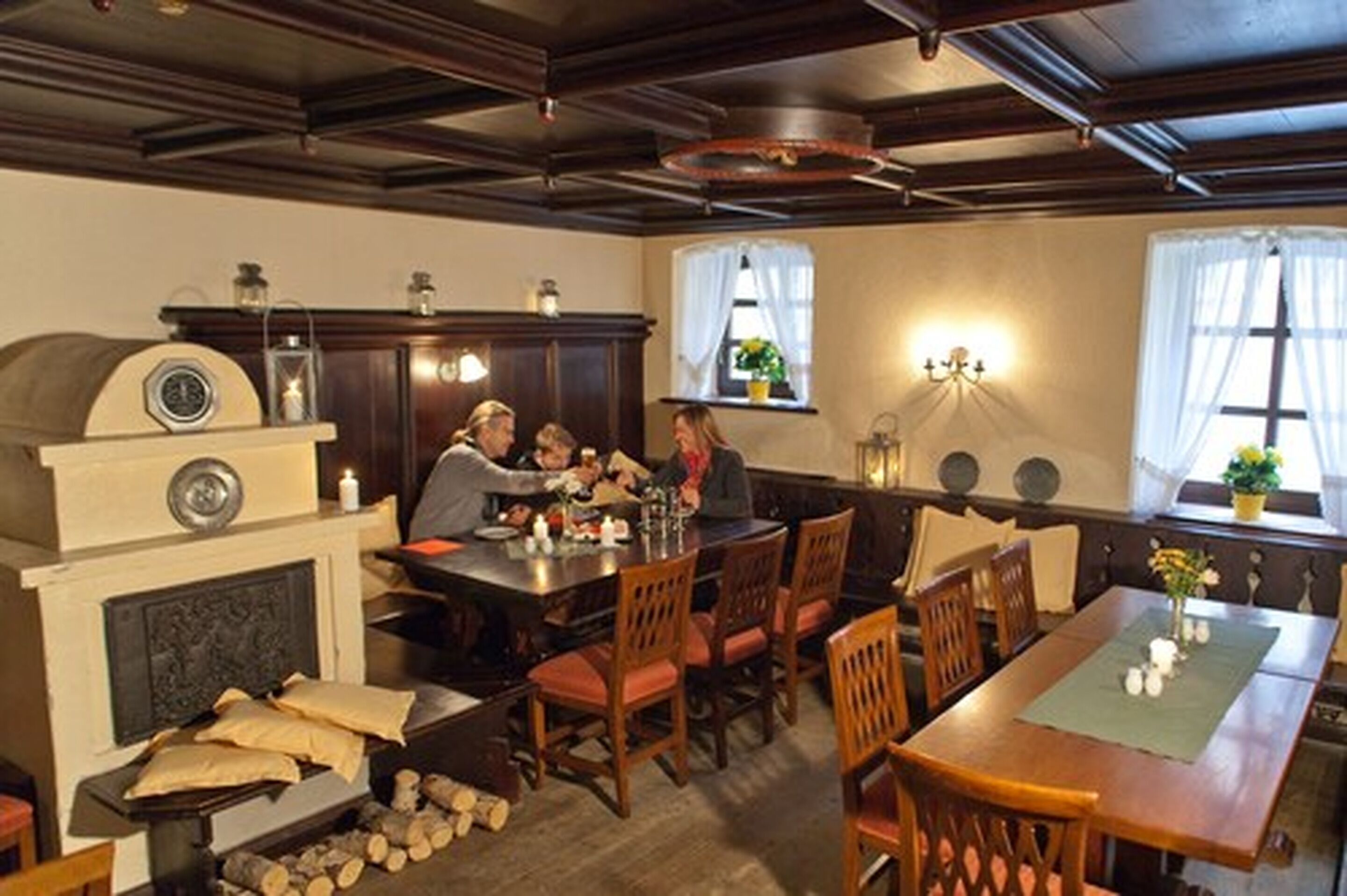 A cozy dining area with wooden furniture, a fireplace, and a chandelier.