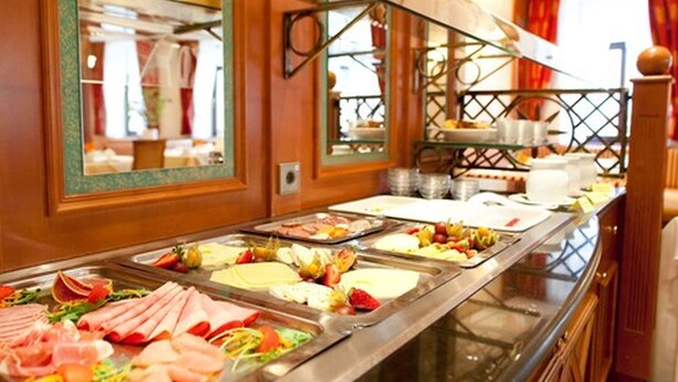 Un bufé con diferentes opciones de comida y un espejo que refleja el salón.