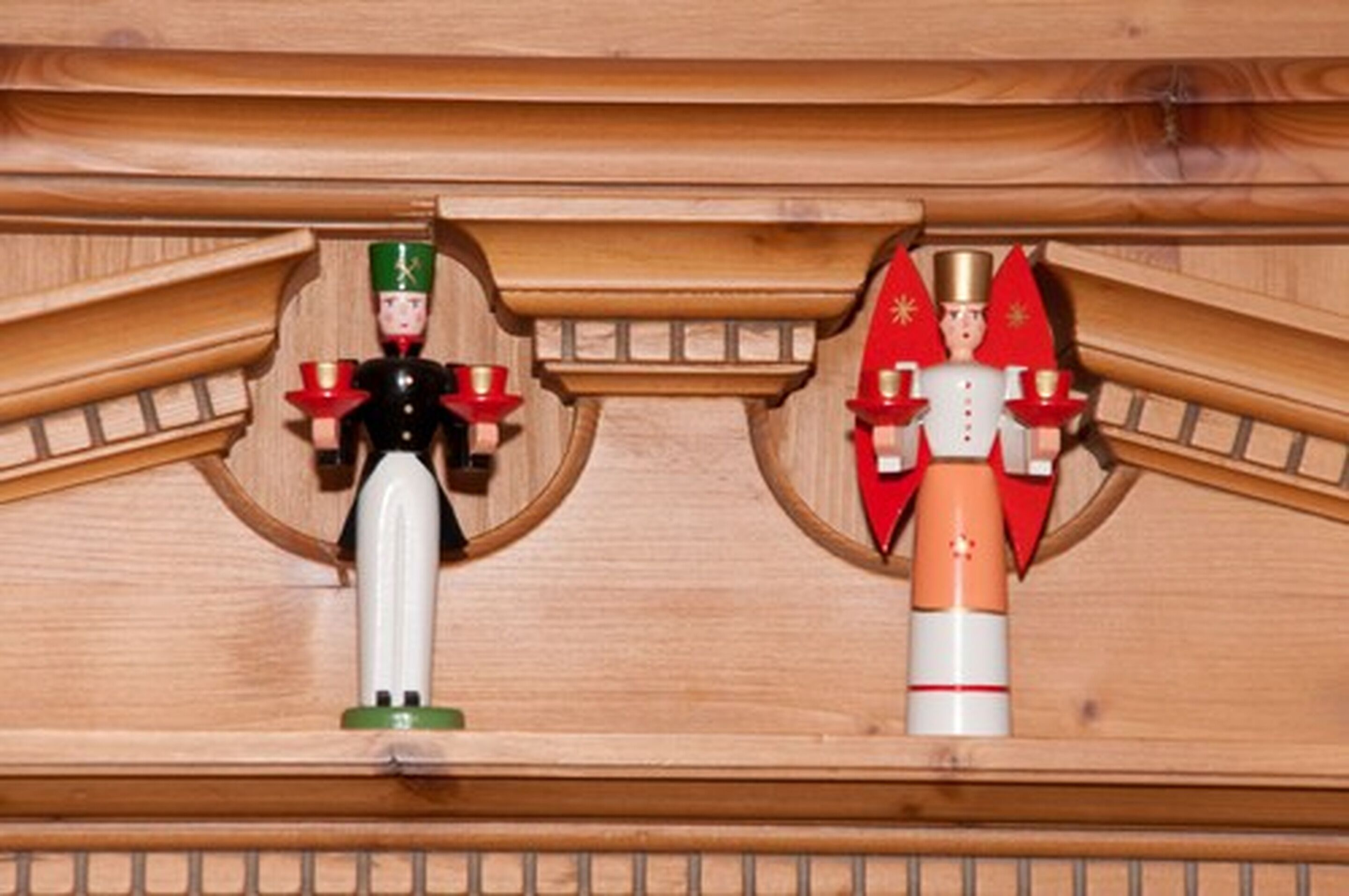 Dos figuras de cascanueces de madera sobre una estantería.