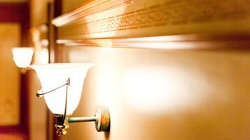Detalhe de uma parede com moldura metálica e luminária.