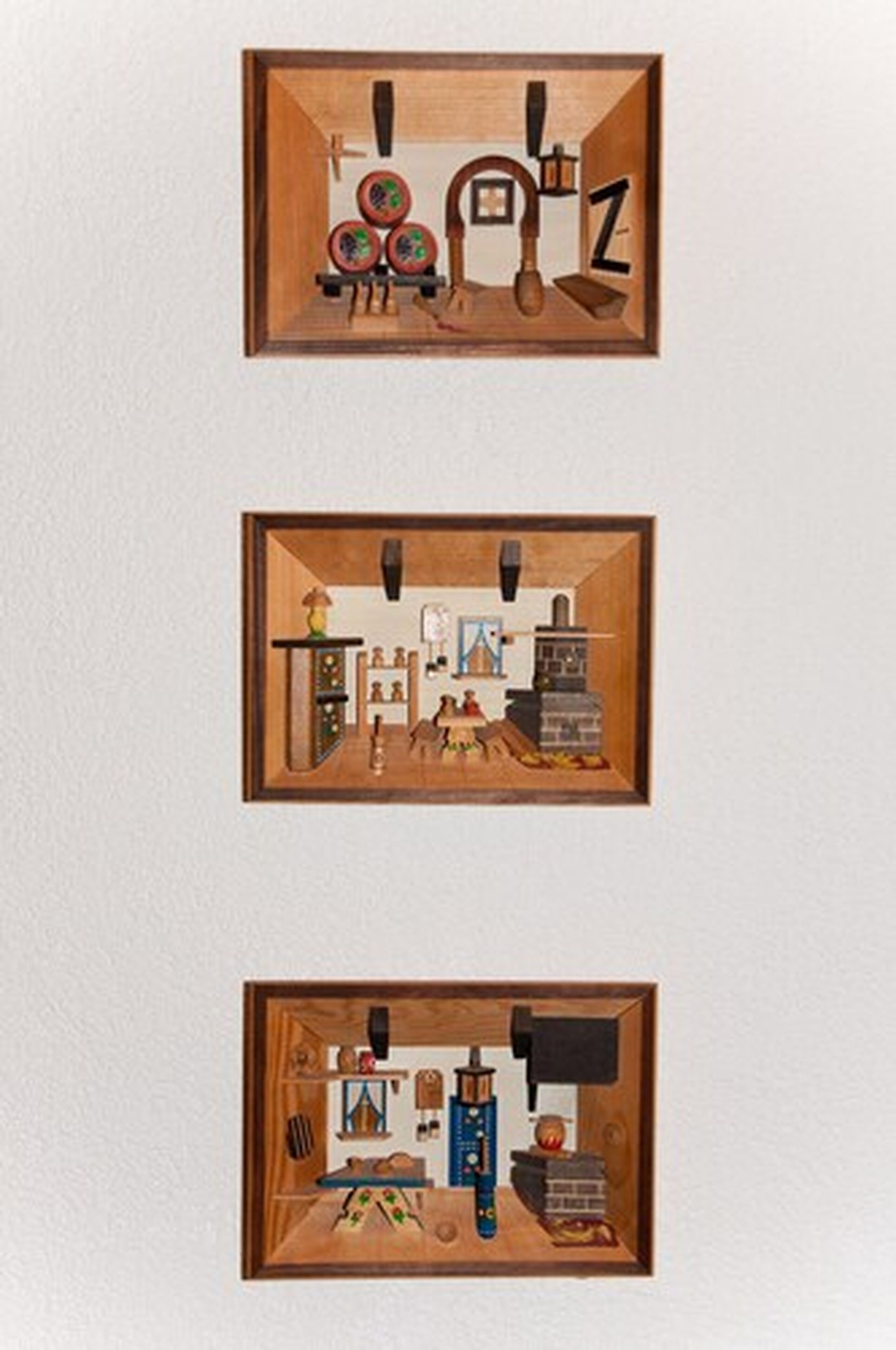 Three framed interior scenes with wooden frames, each depicting a different room layout with furniture and objects.