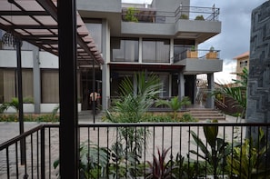 A modern multi-story building with balconies, a covered entrance, and surrounding greenery. - The Venti Hotel & Spa (Kampala)