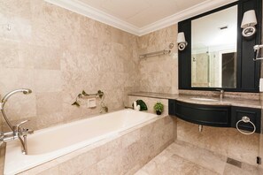 Une salle de bain moderne avec une baignoire sur pieds, un meuble-lavabo avec un miroir et un porte-serviettes.