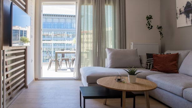 Un salon moderne avec un canapé, une table basse et un téléviseur fixé au mur.