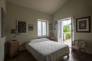 A bedroom with a bed, a nightstand, a chair, and a window. - Villa Mirella Beach (Fermo)