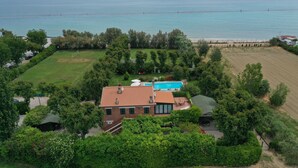 A house with a swimming pool, surrounded by lush greenery and a view of the sea. - Villa Mirella Beach (Fermo)