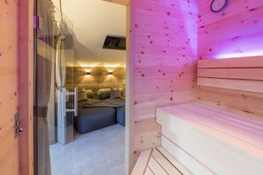 Een sauna met een glazen deur, houten banken en een klok aan de muur.