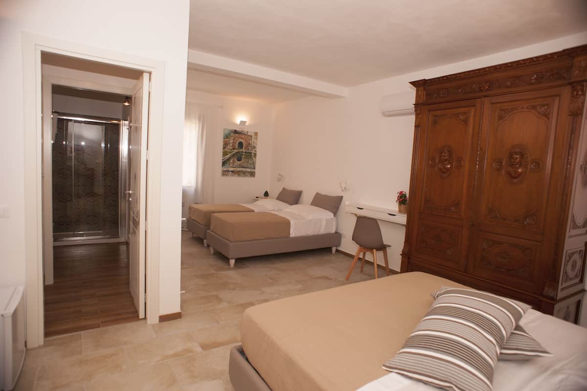 Een slaapkamer met een bed, twee nachtkastjes, een garderobe en een douche.