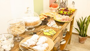 A buffet table with various food items, including pastries, fruits, and a watermelon slice. - B&B Nencioli (Castellammare del Golfo)