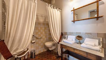 Ein Badezimmer mit Toilette, Waschbecken mit Spiegel und Duschvorhang.