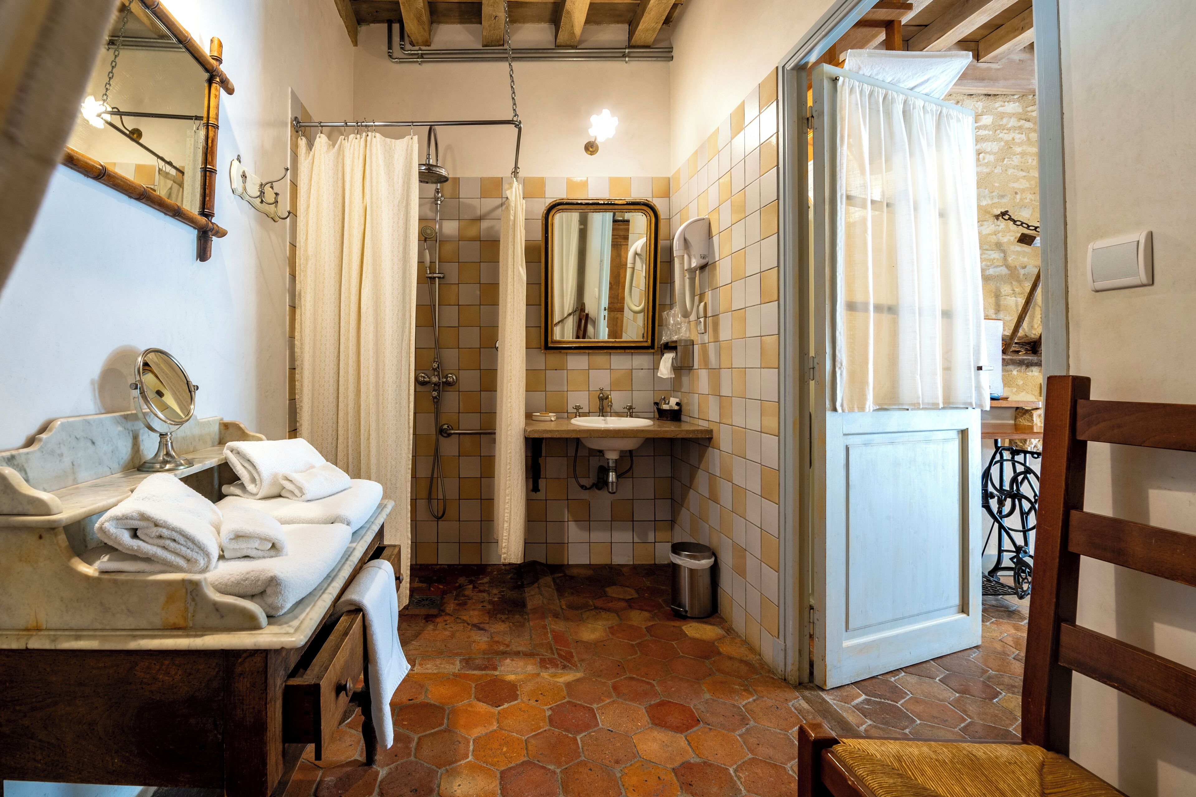 Une salle de bain équipée d’un lavabo, d’un miroir et d’un espace douche.