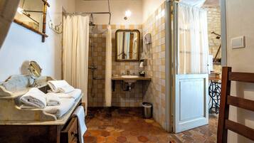 Une salle de bain équipée d’un lavabo, d’un miroir et d’un espace douche.