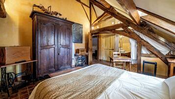 Une chambre à coucher avec un grand lit, une armoire en bois et un plafond rustique.