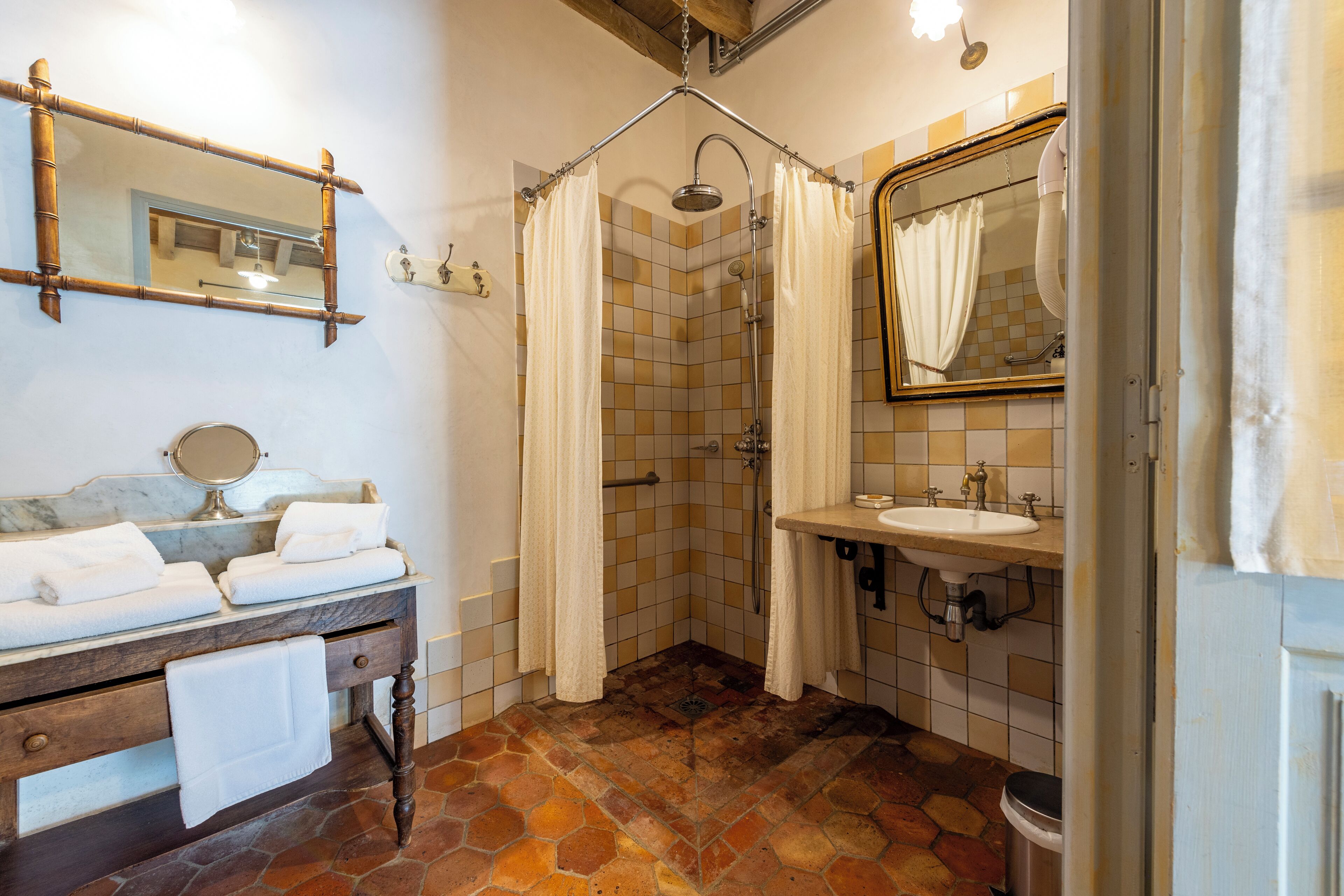 Une salle de bain équipée d’une douche, d’un lavabo, d’un miroir et d’un meuble-lavabo avec des serviettes.