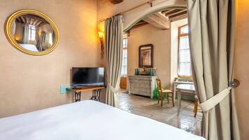 A hotel room with a bed, a television, a dresser, and a mirror.