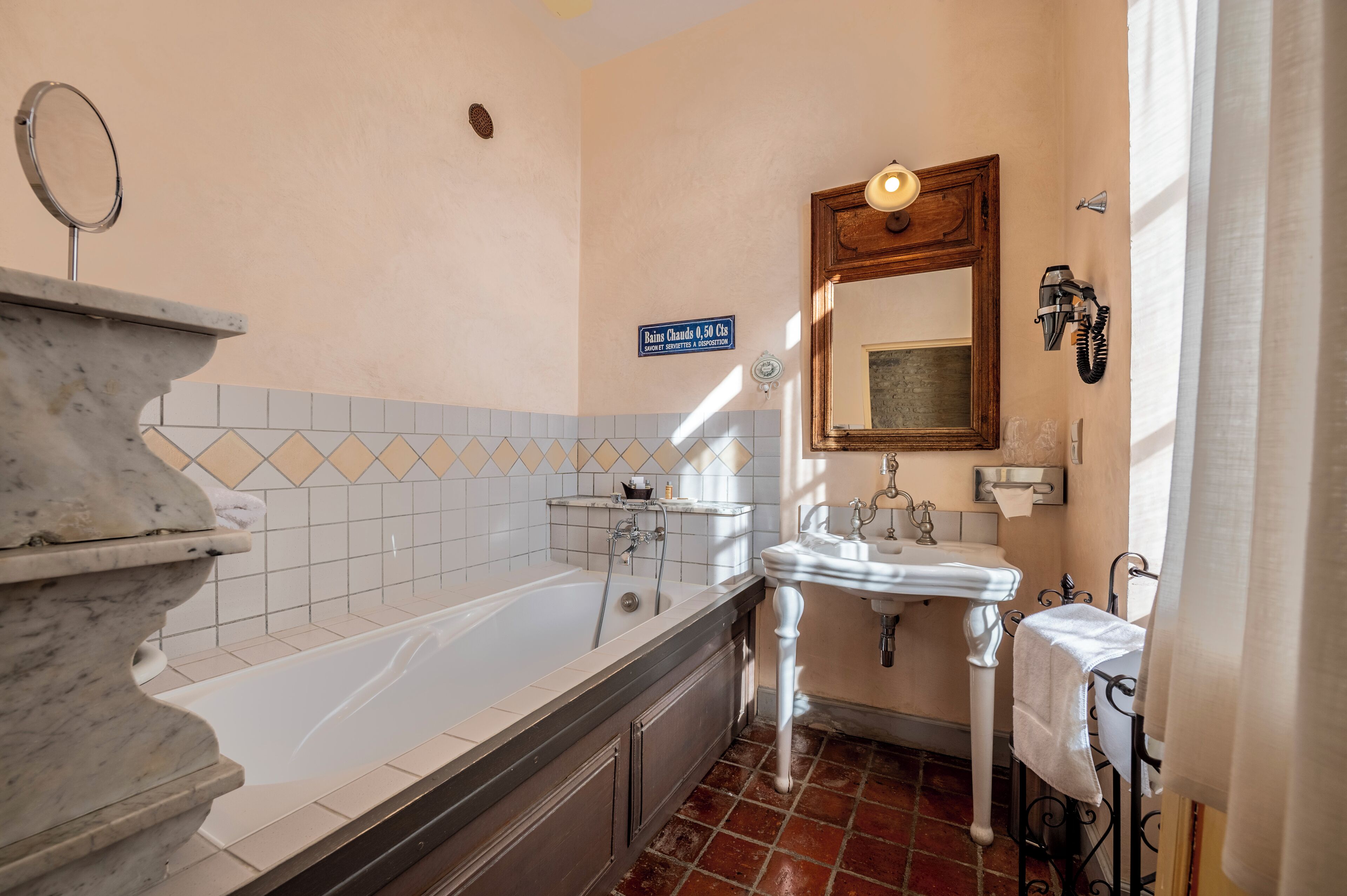 Une salle de bain avec une baignoire, un lavabo et un miroir.