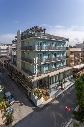 A multi-story hotel with balconies, a covered outdoor seating area, and a no-entry sign. - Hotel Aurora Mare (Rimini)