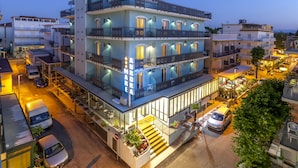 A multi-story hotel with balconies, a ground floor restaurant, and a visible staircase leading to the entrance. - Hotel Aurora Mare (Rimini)
