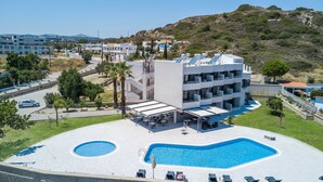 A modern hotel with a rooftop pool, multiple balconies, and a view of the surrounding landscape. - Madison Boutique (Rhodes)