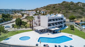 Una piscina al aire libre de temporada, sombrillas