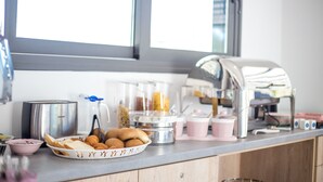 A breakfast buffet setup with a toaster, coffee maker, and various food items on a countertop. - Madison Boutique (Rhodes)