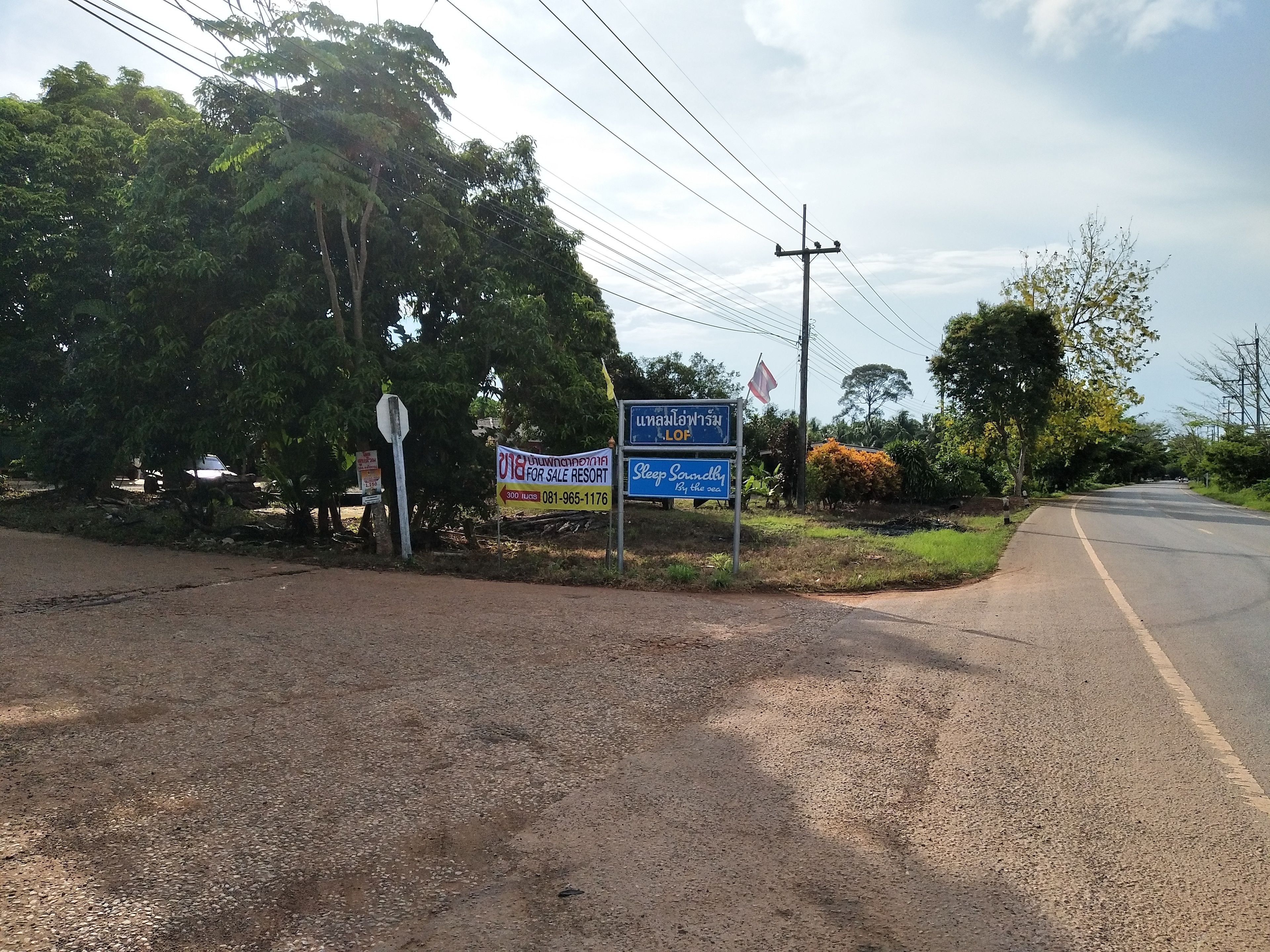 A signboard for a resort with a contact number and a slogan.
