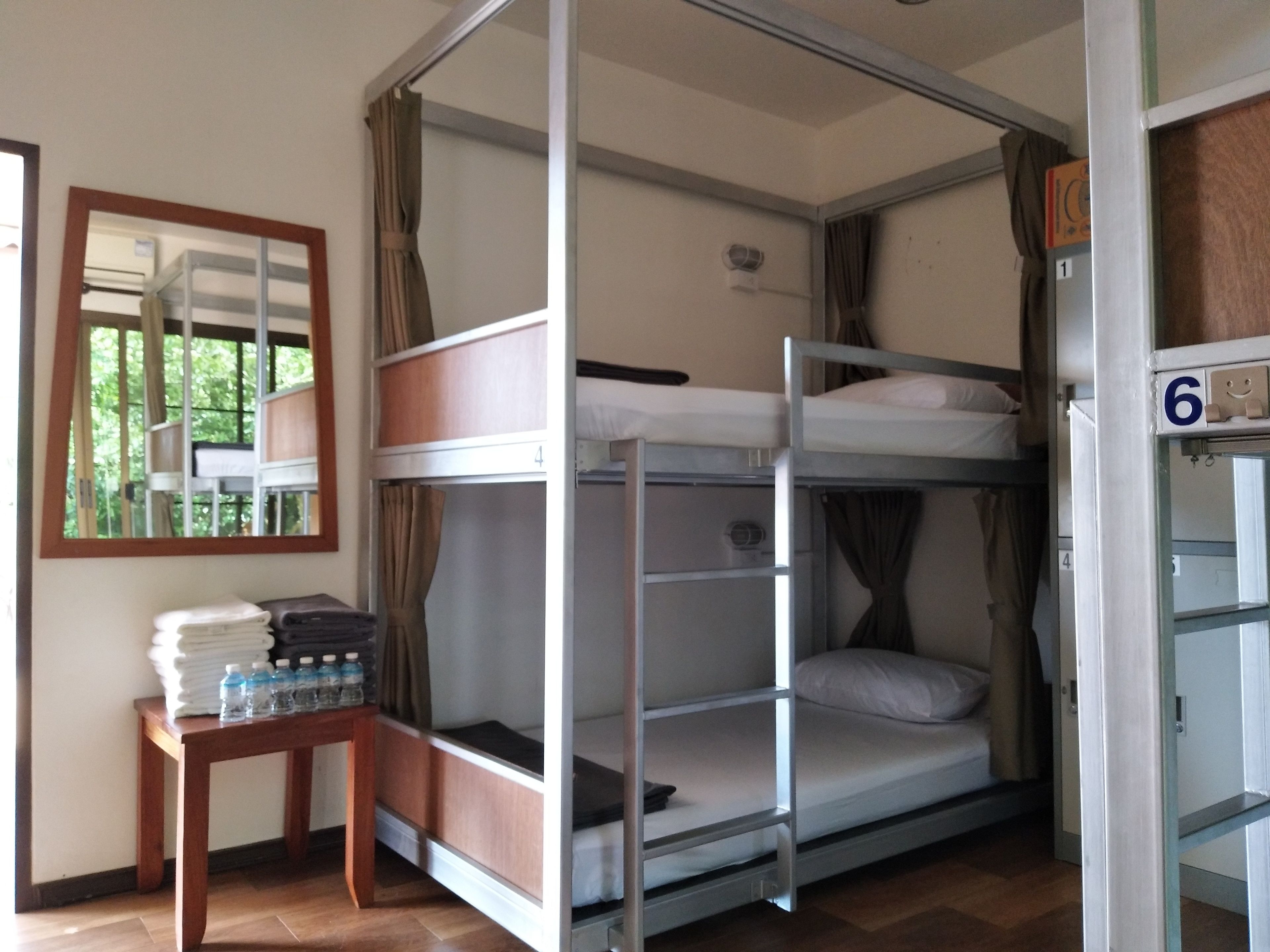 A bunk bed room with a table and water bottles.